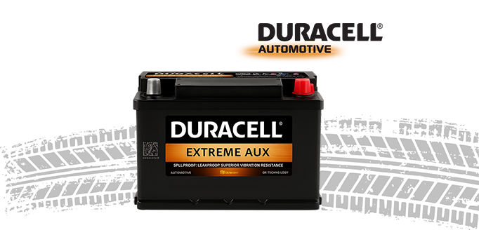 Duracell Extreme AUX automotive battery with red and silver terminals on a tire tread background